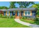 Charming renovated home with blue painted brick, light blue door, new gray roof, wood porch and accent shutters at 2116 Eastway Dr, Charlotte, NC 28205