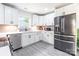 Bright renovated kitchen featuring white cabinets, stainless steel appliances, and new luxury vinyl plank flooring at 2116 Eastway Dr, Charlotte, NC 28205