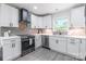 Bright kitchen with white cabinets, stainless steel appliances, and gray backsplash at 2116 Eastway Dr, Charlotte, NC 28205