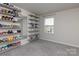 Bright bedroom features neutral walls, carpet floors, and extensive shelving for shoe storage at 2116 Morgan Hills Dr, Albemarle, NC 28001