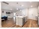 Open-concept kitchen featuring a central island, stainless steel appliances, and stylish pendant lighting at 2116 Morgan Hills Dr, Albemarle, NC 28001