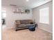 Cozy living room features comfortable gray sofa, blue ottoman, and decor shelf at 2116 Morgan Hills Dr, Albemarle, NC 28001