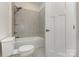 This bathroom features a toilet, bath tub, and shower with gray tiled walls at 218 Tetcott St, Mooresville, NC 28115