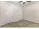 This bedroom features neutral carpeting, a ceiling fan, and two doors at 218 Tetcott St, Mooresville, NC 28115