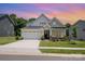 Charming single-Gathering home featuring a two-car garage, manicured lawn, and welcoming front porch at sunset at 218 Tetcott St, Mooresville, NC 28115