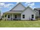 View of the rear of the house showing an outdoor seating area with a well maintained lawn at 218 Tetcott St, Mooresville, NC 28115