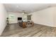 Open-concept living room boasts wood floors, neutral paint, a ceiling fan, and natural light from large windows at 218 Tetcott St, Mooresville, NC 28115