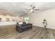 Open-concept living room boasts a sofa, wood floors, modern lighting, and natural light from the open kitchen at 218 Tetcott St, Mooresville, NC 28115