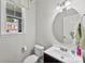 Clean and simple half bathroom with a modern vanity, round mirror, and neutral wall color at 237 River Clay Rd, Fort Mill, SC 29708