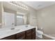Bathroom featuring double sinks, a large mirror, and a shower/tub combo with a white curtain at 237 River Clay Rd, Fort Mill, SC 29708
