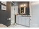 Contemporary bathroom features a walk-in shower with white tile, dark walls, and a marble vanity at 2514 Marshall Pl, Charlotte, NC 28203