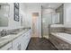A luxurious bathroom with a double vanity, granite countertop, and a glass-enclosed shower with stone accents at 2514 Marshall Pl, Charlotte, NC 28203