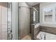A detailed view of a modern bathroom featuring a glass shower door, stone walls, and a tiled tub at 2514 Marshall Pl, Charlotte, NC 28203