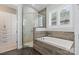 This bathroom features a tub, shower with glass door, stone tile, and light-filled window at 2514 Marshall Pl, Charlotte, NC 28203