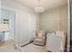 Cozy Bedroom with paneled walls, patterned carpet, stylish chandelier, and a comfortable armchair at 2514 Marshall Pl, Charlotte, NC 28203
