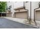 A two car attached garage with gray doors and a driveway in front of a cream home at 2514 Marshall Pl, Charlotte, NC 28203