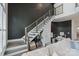 Modern living room with open staircase, dark accent wall, neutral sofa, and stylish bar cart at 2514 Marshall Pl, Charlotte, NC 28203