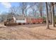 View of the house's backyard, including the brick, white siding, and the deck with trees at 3515 Back Creek Church Rd, Charlotte, NC 28213