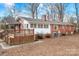 View of the house's backyard, including the brick, white siding, and the deck at 3515 Back Creek Church Rd, Charlotte, NC 28213