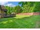 A sprawling backyard with lush green grass and a wooden fence at 3831 Riceland Pl, Charlotte, NC 28216