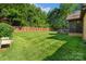 Large, well-manicured backyard with a wooden fence and screened-in porch for outdoor enjoyment at 3831 Riceland Pl, Charlotte, NC 28216