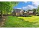 View of backyard with lush lawn, screened-in porch, and wooden deck at 3831 Riceland Pl, Charlotte, NC 28216