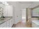 Spacious bathroom features double sinks, granite counters, white cabinets, soaking tub and glass shower at 3831 Riceland Pl, Charlotte, NC 28216