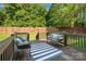 Relaxing deck with comfortable seating, a blue and white rug and wood railing at 3831 Riceland Pl, Charlotte, NC 28216