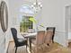 Bright dining room with large window, chandelier, and seating for six at 3831 Riceland Pl, Charlotte, NC 28216