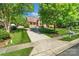 Suburban home with verdant lawn and mature trees lining a paved driveway at 3831 Riceland Pl, Charlotte, NC 28216