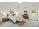 Bright main bedroom featuring a large bed, bench seating, tray ceiling and dual bedside tables at 3831 Riceland Pl, Charlotte, NC 28216