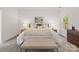Bright main bedroom featuring a large bed, bench seating, tray ceiling and dual bedside tables at 3831 Riceland Pl, Charlotte, NC 28216
