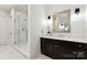 Stylish bathroom showcasing a dark vanity with a white countertop and a frameless glass shower at 408 Ideal Way, Charlotte, NC 28203