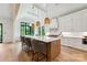 Bright, modern kitchen with large island, pendant lighting, stainless appliances, and hardwood floors at 408 Ideal Way, Charlotte, NC 28203