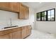 Bright laundry room with custom wood cabinets, sleek sink, and a large window for natural light at 408 Ideal Way, Charlotte, NC 28203