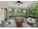 Relaxing screened porch with comfortable seating, ceiling fan, and serene views of the surrounding landscape at 408 Ideal Way, Charlotte, NC 28203