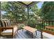 Cozy covered balcony with comfortable seating and a view of the lush backyard at 4117 Sarah Dr, Charlotte, NC 28217