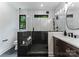 Stylish bathroom features tiled shower with glass enclosure and dark wood vanity at 4117 Sarah Dr, Charlotte, NC 28217