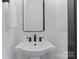 Modern powder room featuring a pedestal sink, matte black faucet, and square mirror at 4117 Sarah Dr, Charlotte, NC 28217