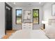 Bright bedroom featuring wood floors, black window frames, and a modern dresser with decorative artwork at 4117 Sarah Dr, Charlotte, NC 28217