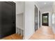 Entryway featuring hardwood floors, black doors, and a built-in bench with storage at 4117 Sarah Dr, Charlotte, NC 28217