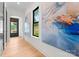 Bright hallway featuring hardwood floors, contemporary artwork, and a view to the outside at 4117 Sarah Dr, Charlotte, NC 28217