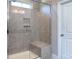 Modern bathroom shower featuring tiled walls, glass door, and a built-in bench for added comfort at 4333 Legacy Dr, Denver, NC 28037