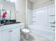 Bright bathroom featuring a marble countertop vanity, a tub with tile surround, and modern fixtures at 4333 Legacy Dr, Denver, NC 28037