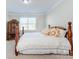 Cozy bedroom with a decorative bed frame, armoire, and soft natural light at 4333 Legacy Dr, Denver, NC 28037