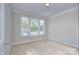 Well-lit bedroom with neutral walls, carpet flooring, and large windows offering plenty of natural light at 4333 Legacy Dr, Denver, NC 28037