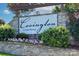Community entrance sign with stone accents surrounded by lush greenery and flowers at 4333 Legacy Dr, Denver, NC 28037