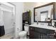 Well-lit bathroom with a modern vanity, decorative wallpaper, and a combined tub and shower at 5059 Fenwick Ct, Lancaster, SC 29720