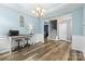 Spacious dining area with light blue walls, hardwood floors, and access to staircase at 5059 Fenwick Ct, Lancaster, SC 29720