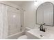 White bathroom featuring shower-tub combo, sleek vanity, and round mirror, ideal for relaxing at 5229 Tarrywood Ln, Charlotte, NC 28205